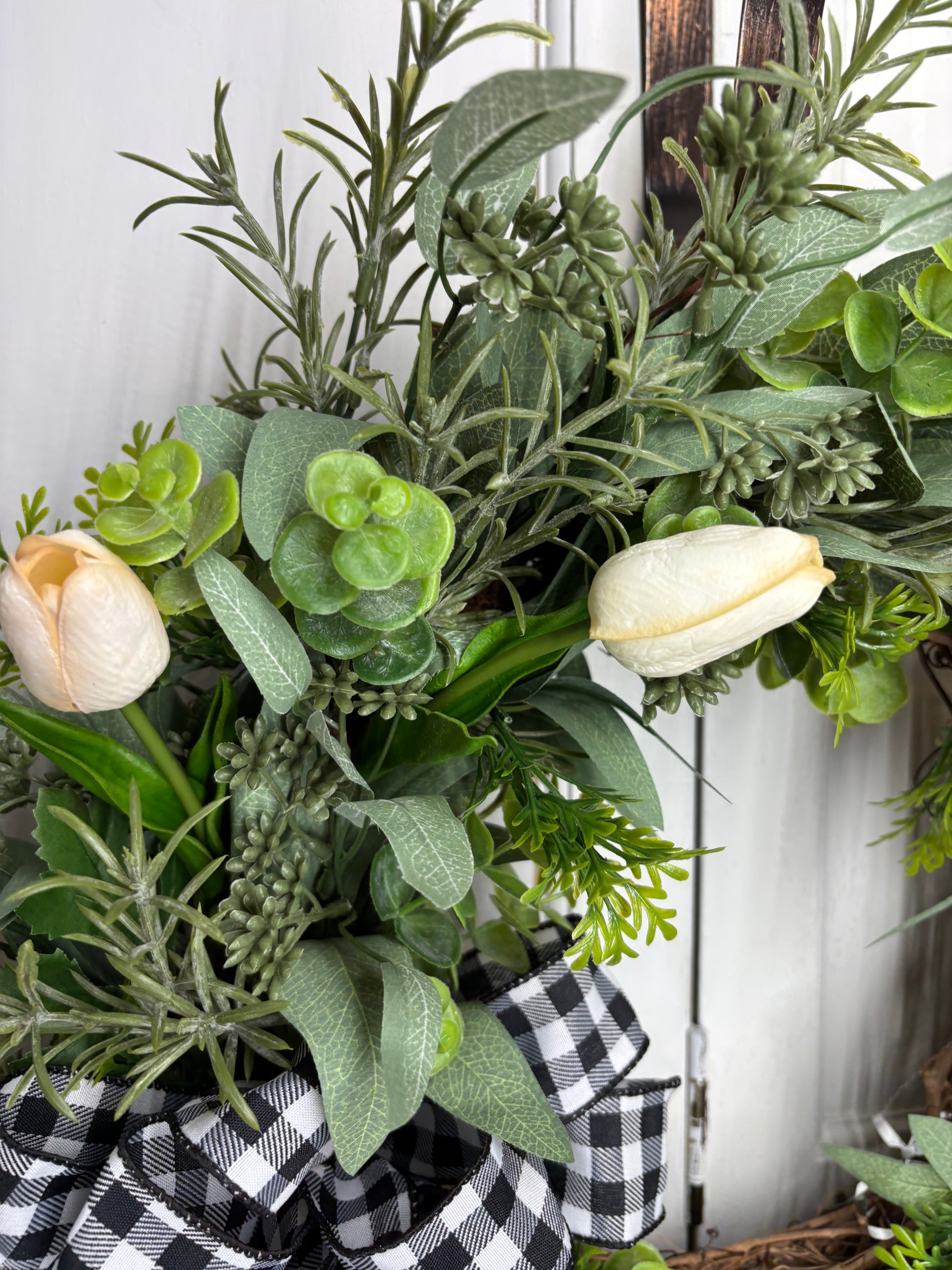 Spring tulip wreath featuring cream tulips, eucalyptus, and a black and white checkered bow on a grapevine base.