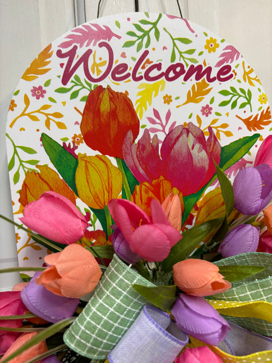 Spring tulip sign door hanger featuring colorful tulips and a "Welcome" message with decorative ribbon accents.