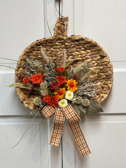 Woven pumpkin door hanger with a gingham bow and colorful floral accents, measuring 15 inches for fall decor.