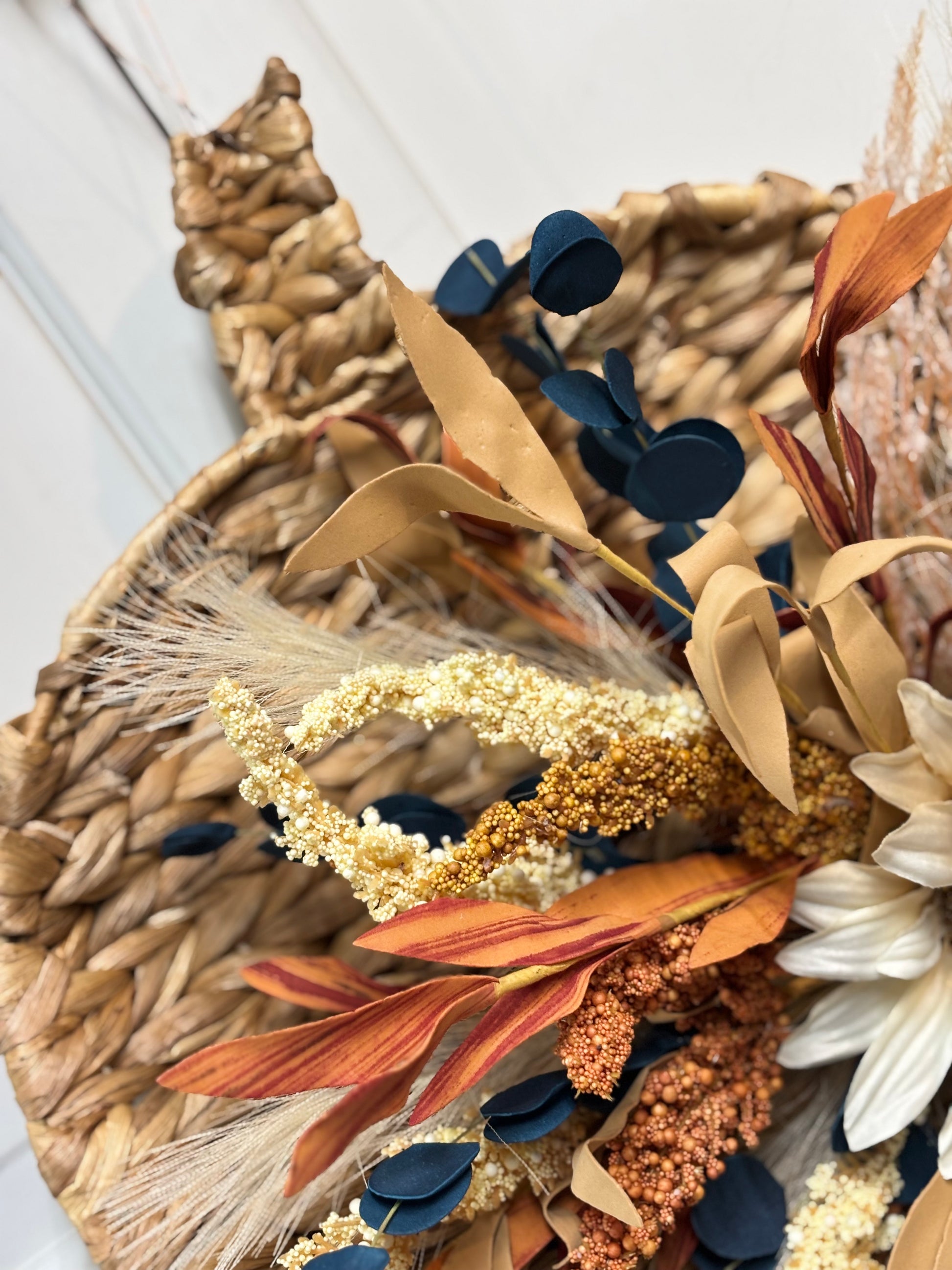 Woven pumpkin door hanger featuring sunflowers and autumn foliage in warm colors, measuring 15 inches.